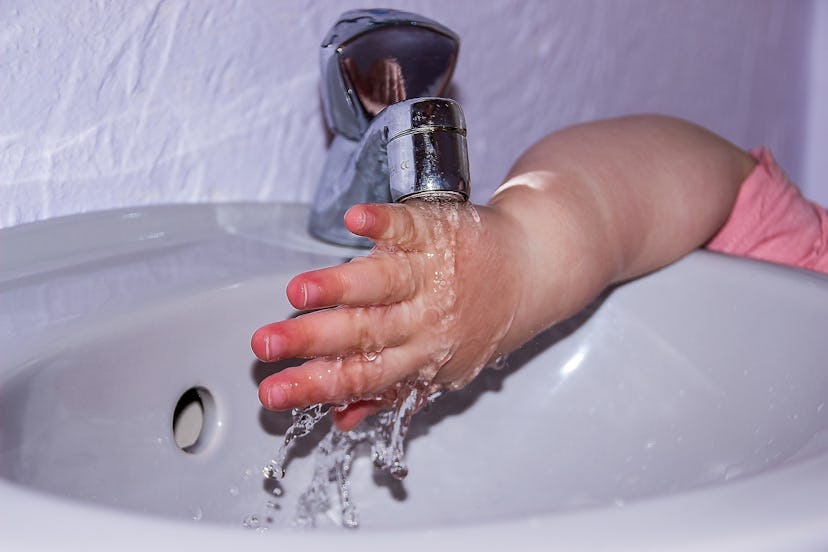 A kid washing hands at a sink