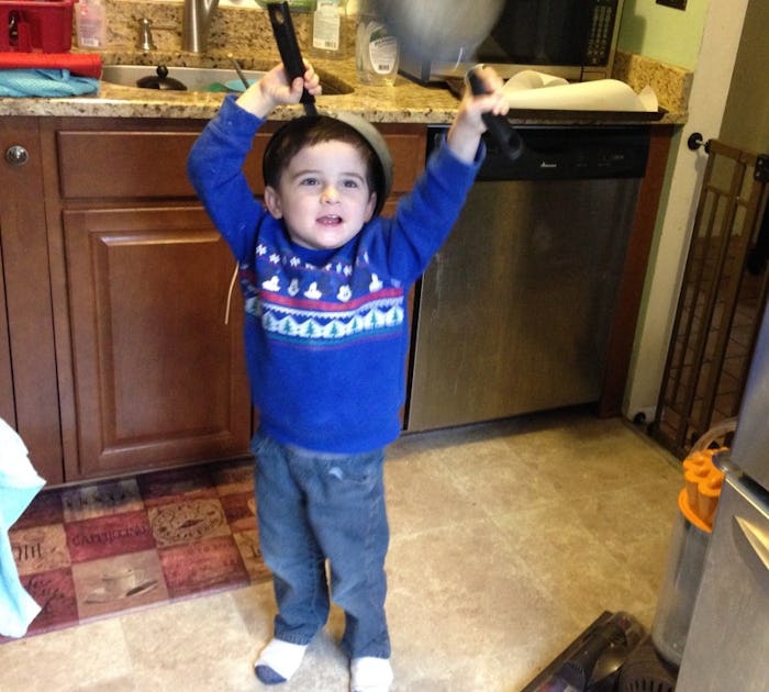 Kid playing with pots and pans in the kitchen