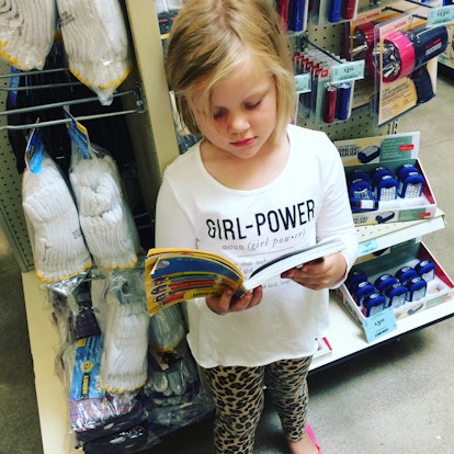 A picture of a little girl reading a book in the store