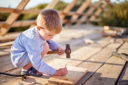 A boy using the hammer and nail