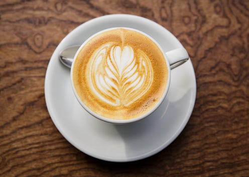 A cup of coffee with intricate flower latte foam art