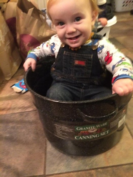 A toddler sitting in a pot