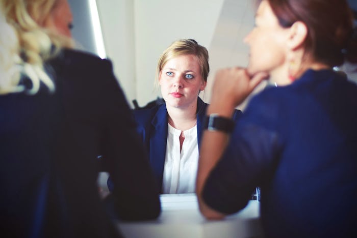Three women at a meeting talking about paid menstrual leave in Italy