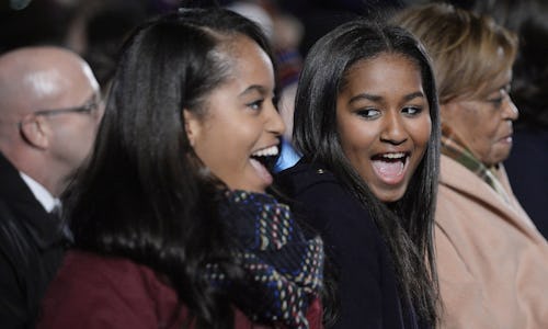 Malia and Sasha Obama laughing together at an event