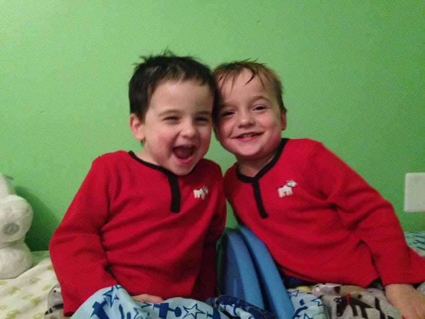 Two toddler brothers in matching pajamas posing for a picture 