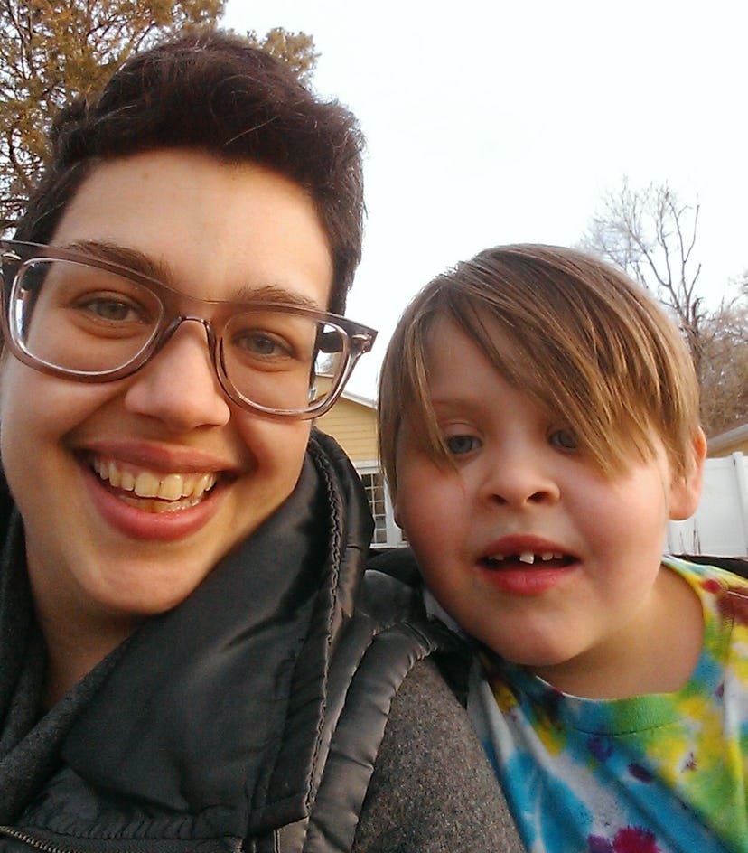 A non-binary transgender person is taking a selfie with a kid.