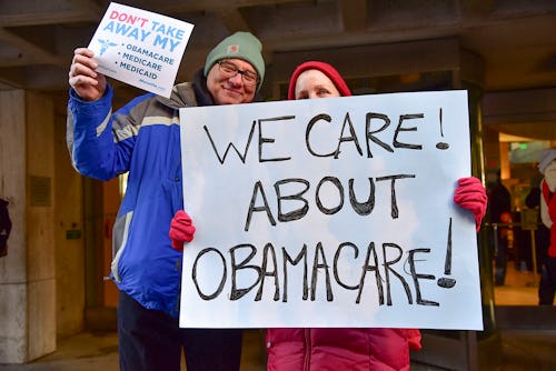 A man and woman with signs about how they care about Obamacare