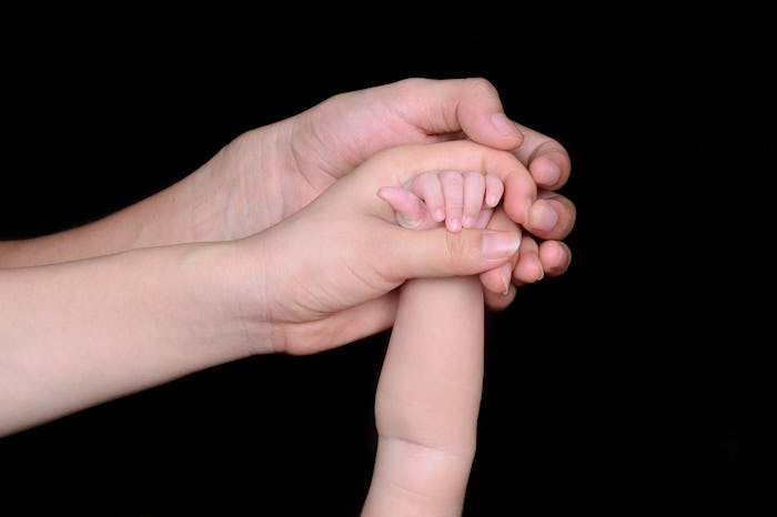 Hands of a baby, mother, and father