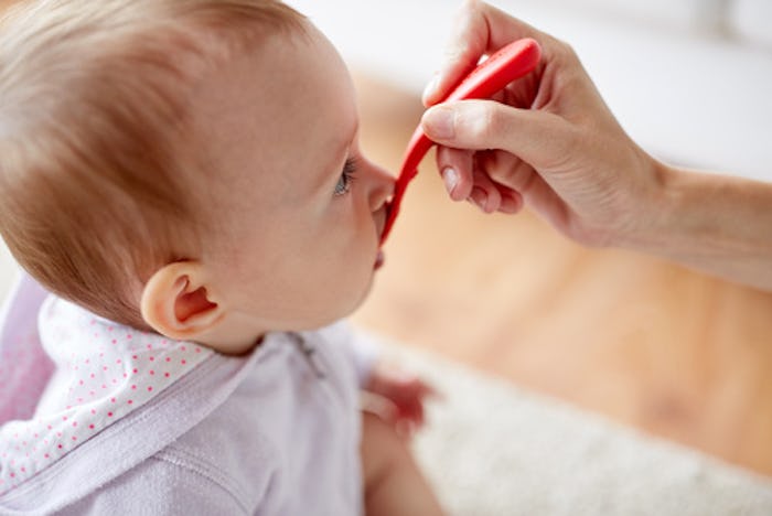 Baby being spoon fed by his mom