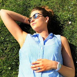 An adult woman celebrating easter by lying on the grass on a sunny day