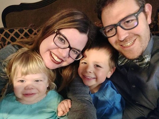 Samantha Taylor and her husband wearing glasses and holding their two children all of them smiling