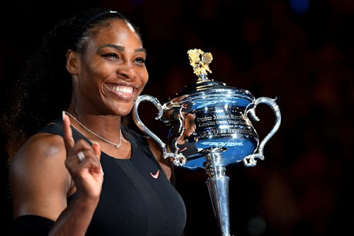 Serena Williams holding up a finger and the Australian Open trophy
