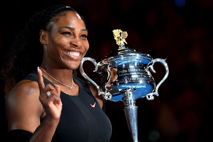 Serena Williams holding up a finger and the Australian Open trophy