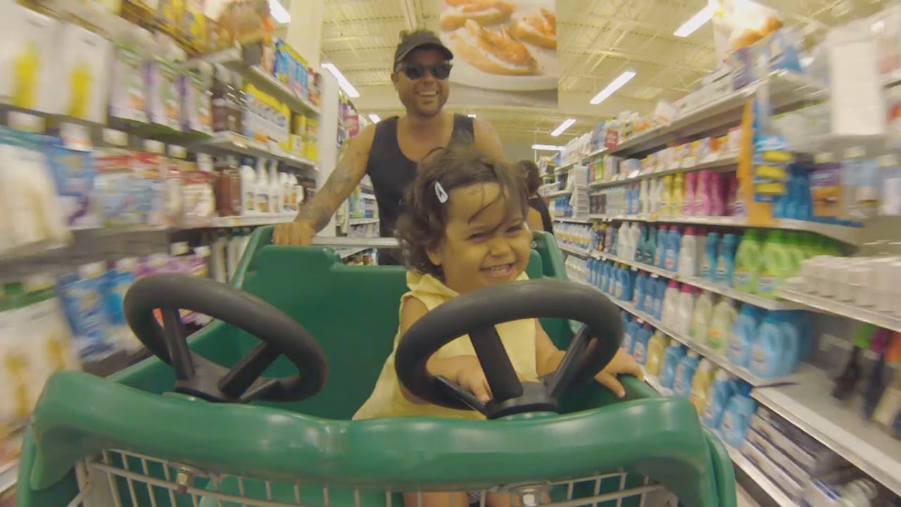 A dad with his daughter in the shopping cart in Dove's #RealDad video