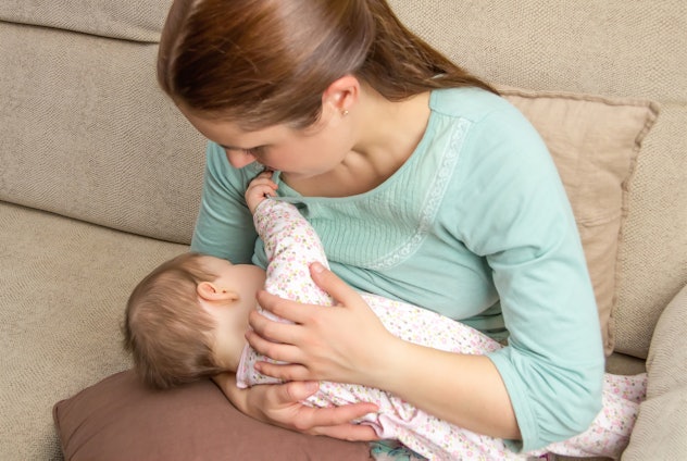 A mom sitting and breastfeeding her baby