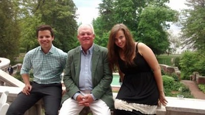 Claire, her father and brother sitting on a balcony in the park