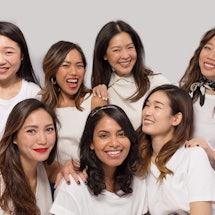 The six Asian women posing together in white shirts