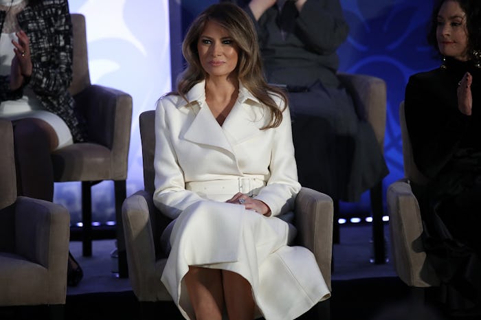 Melania Trump sitting in a white dress