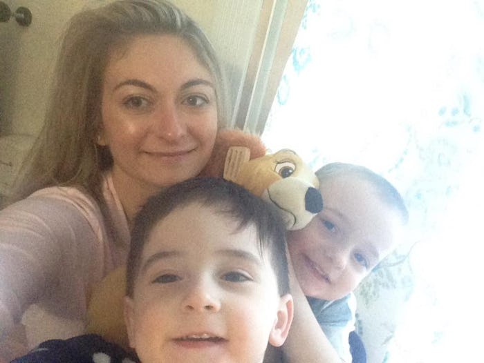 A mother taking a selfie with her two kids