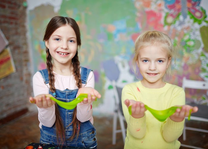 two little girls holding green slime