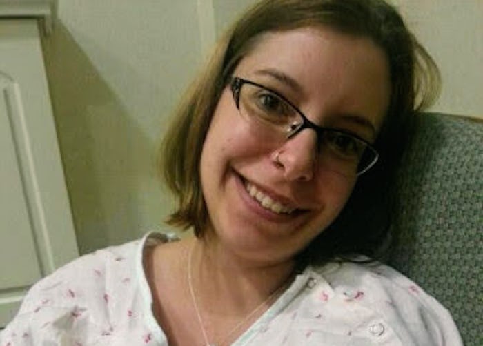 A girl with back labor sitting in hospital white pajamas