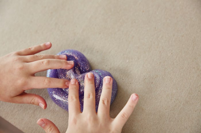 A picture of a child playing with sparkly Elmer's Glue slime.