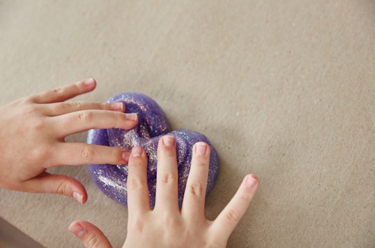 A picture of a child playing with sparkly Elmer's Glue slime. 