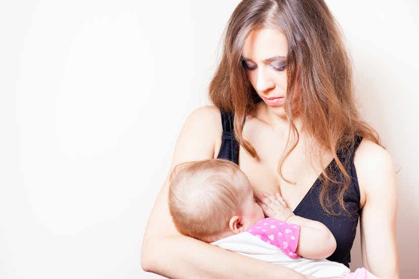 A brunette woman breastfeeding her baby after D-MER