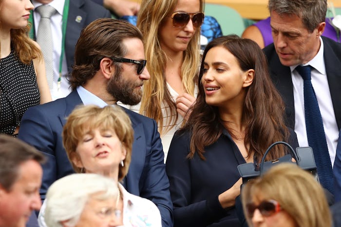 Bradley Cooper in a suit and Irina Shayk in a dress looking at each other at an event