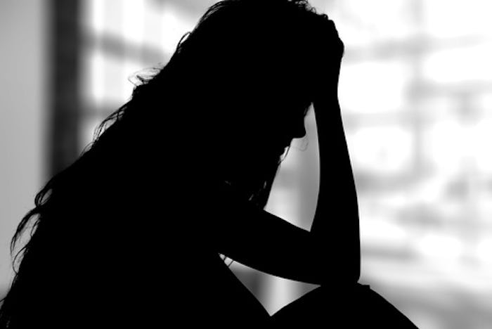 A woman with PPD sitting and holding her head
