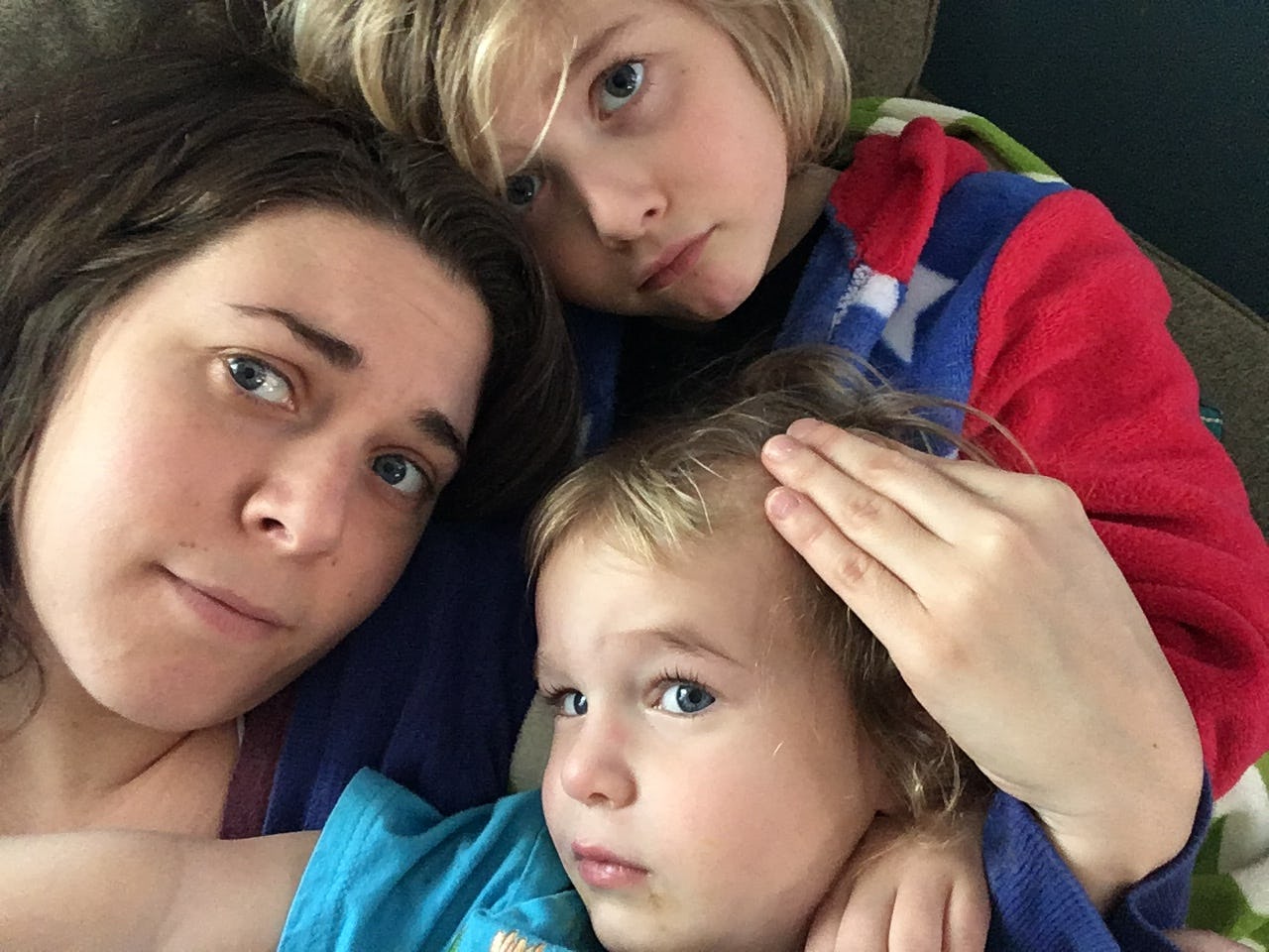 A mother taking a selfie with her two kids