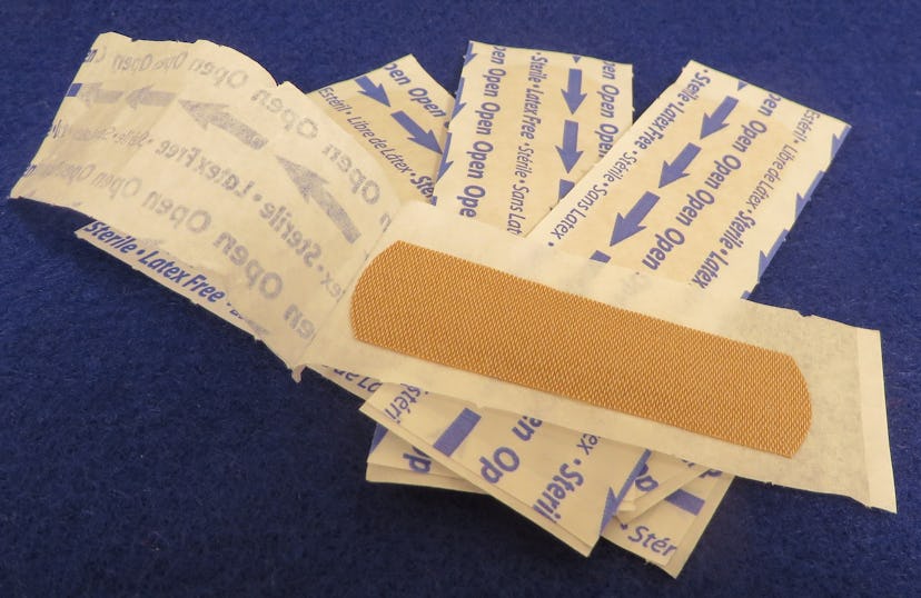 An opened bandage put on multiple packaged ones