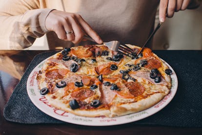 A pre-diabetic woman eating a large pizza after experiencing extreme hunger