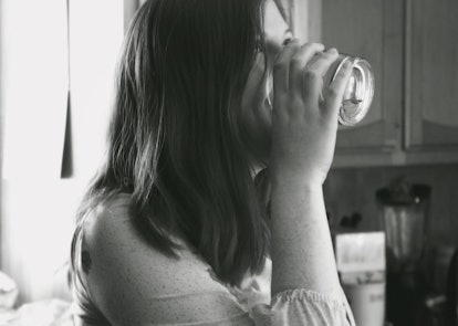A pre-diabetic woman drinking a glass of water after experiencing increased thirst