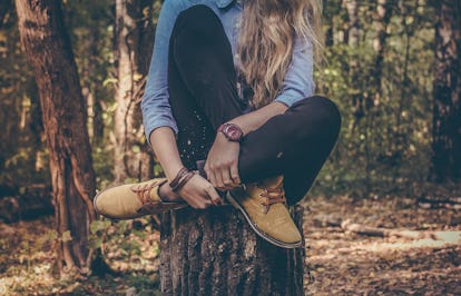 A pre-diabetic woman sitting cross legged on a tree stump needing to urinate