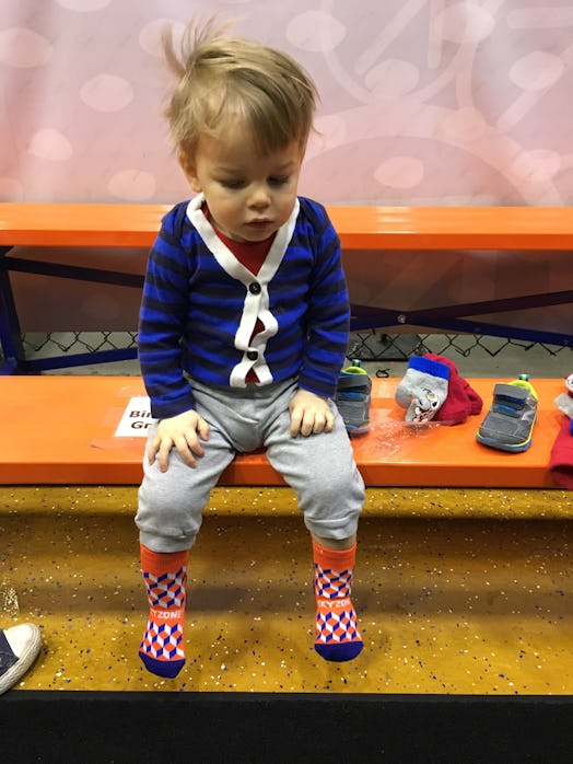 Image of a boy toddler with colorful clothes, sitting on a gym bench
