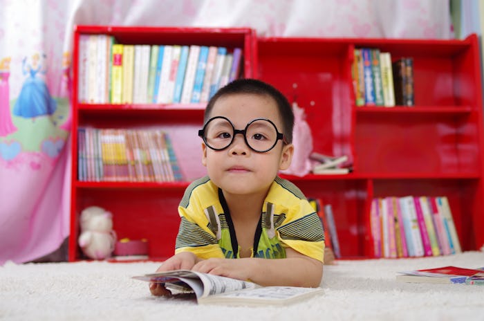 A little boy lying stomach-down on the floor and reading a book to help him understand anxiety