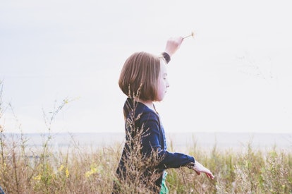 A little girl walks in the meadow