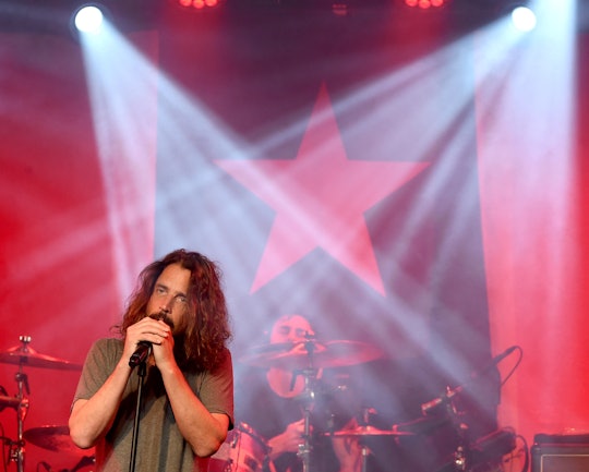 Chris Cornell holding a microphone and singing during his concert