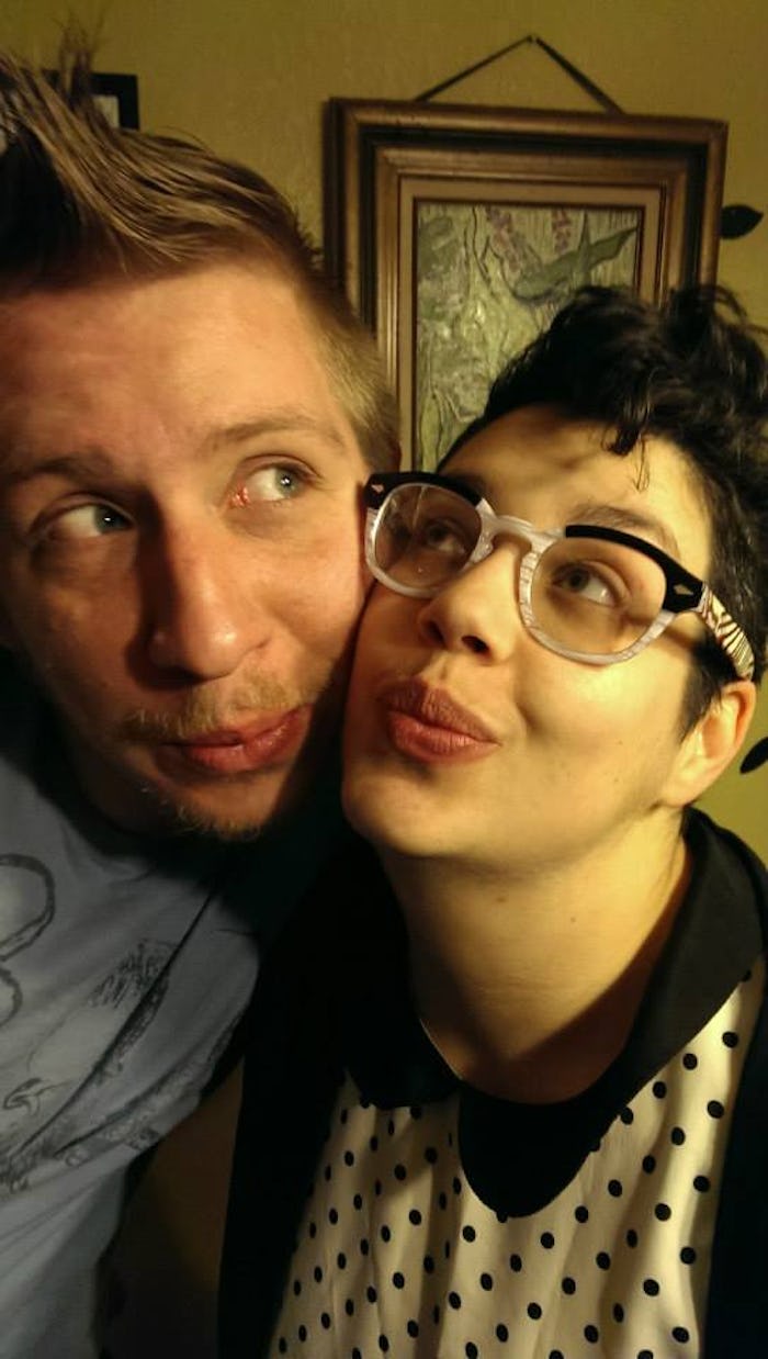 An asexual woman with her partner posing by making kissing faces to each other