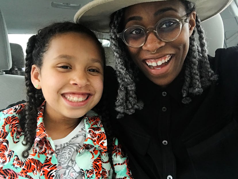 Black parent posing with her daughter in the car, showing how happy they are