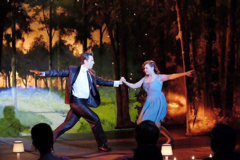 A man in a formal suit and a woman in a blue dress dancing in a "Dirty Dancing" movie scene 