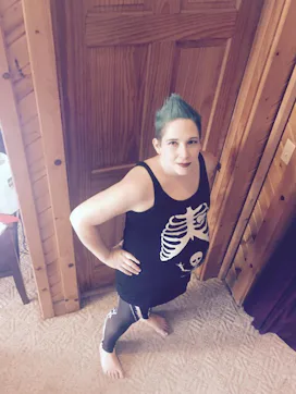 A woman in a skeleton tank top staring up at the camera