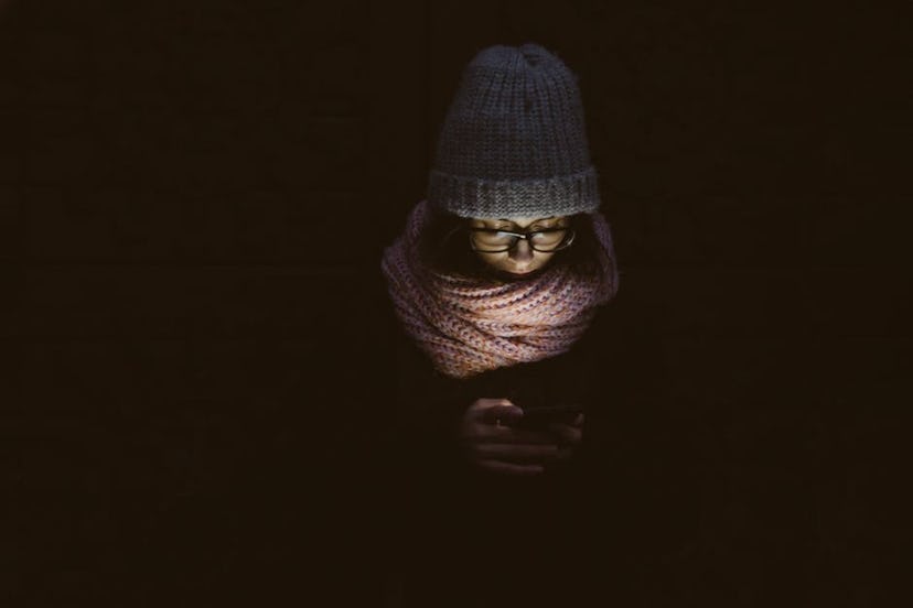 A girl looking in her phone in the darkness