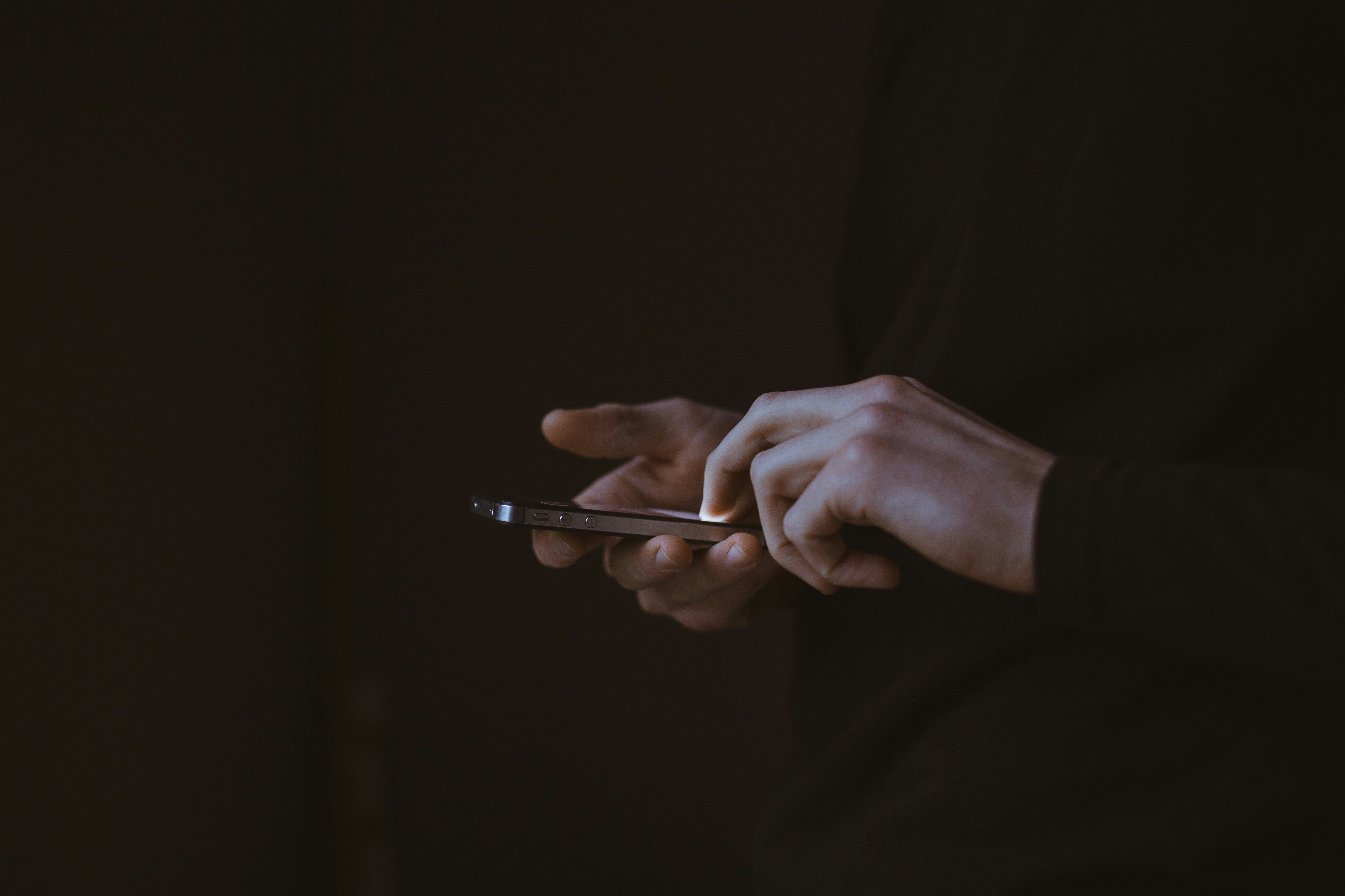 A man in a dark suit using his phone