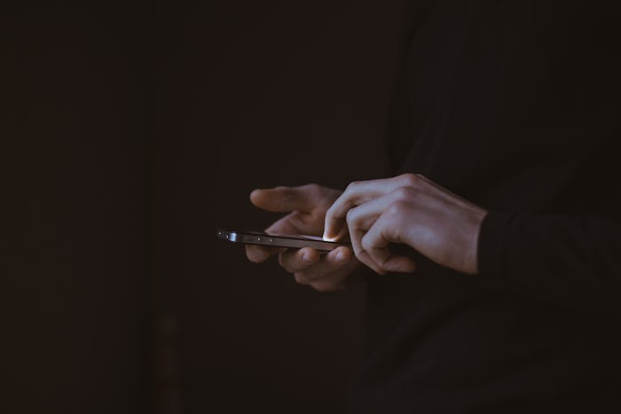 A man in a dark suit using his phone