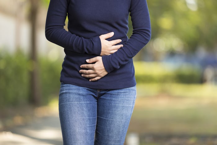 Woman experiencing ectopic pregnancy holding both of her hands over her stomach