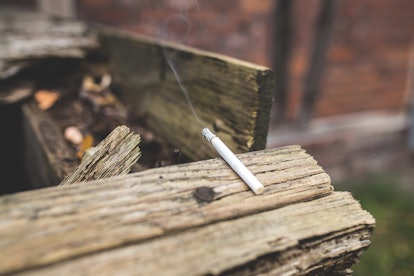 A burning cigarette left on an old wooden shed roof