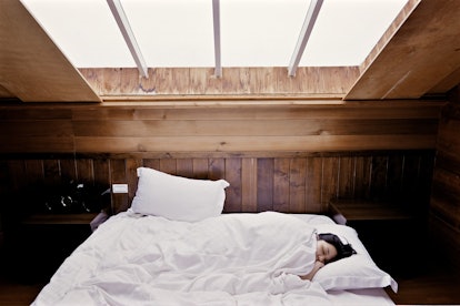 A woman sleeping in a bed with her pillow turned opposite of the bed's heading