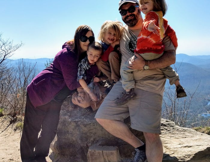 A mother posing with her husband and three kids